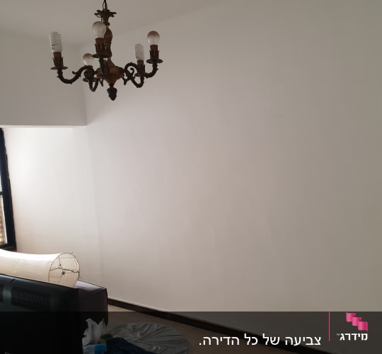 קיר צבוע בלבן עם ניילון לכיסוי רהיטים